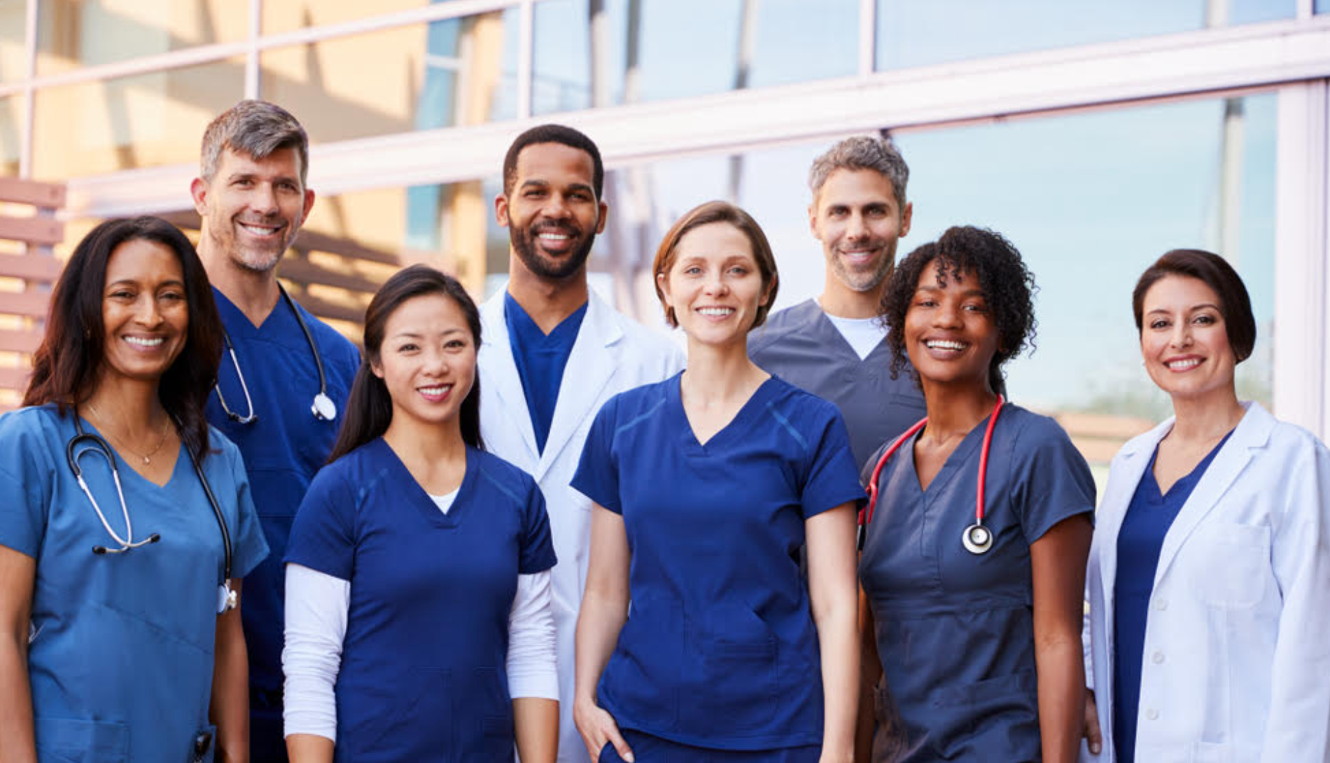 group of 8 people wearing scrubs and medical coat