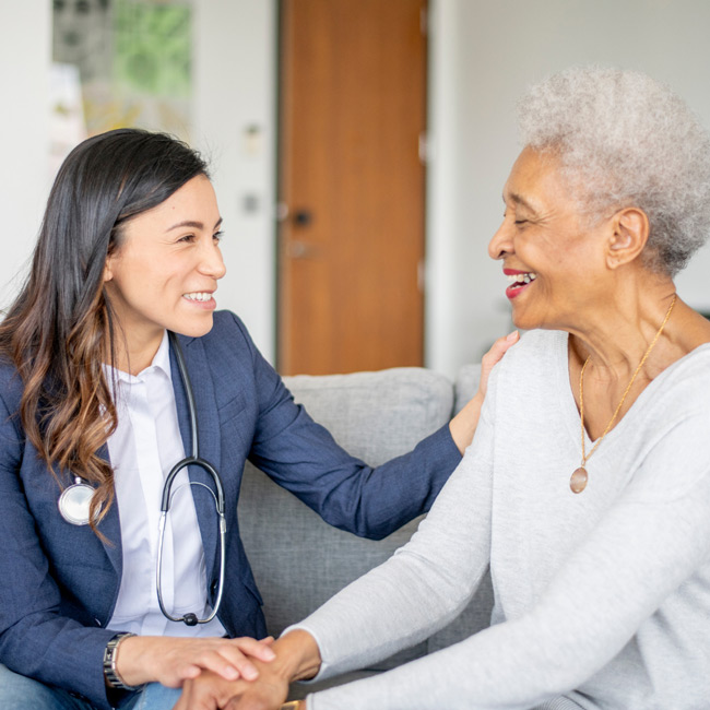 Medical technician holding the hand of an elderly patient