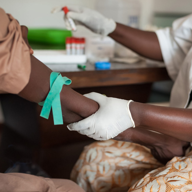 medical technician preparing to draw blood from a patients arm