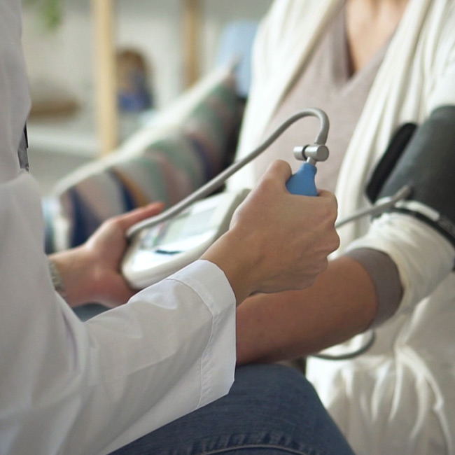 Closeup of a medical technician taking a patient's blood pressure reading