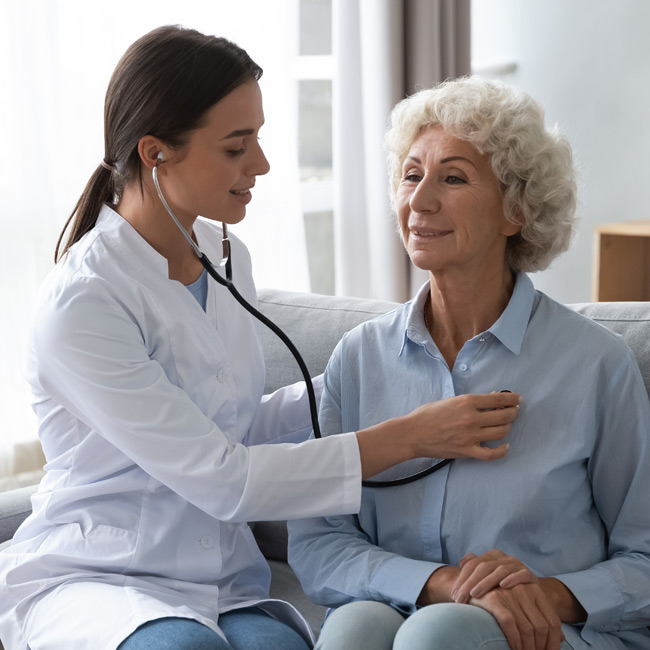 Medical technician listening to the heartbeat of an elderly patient