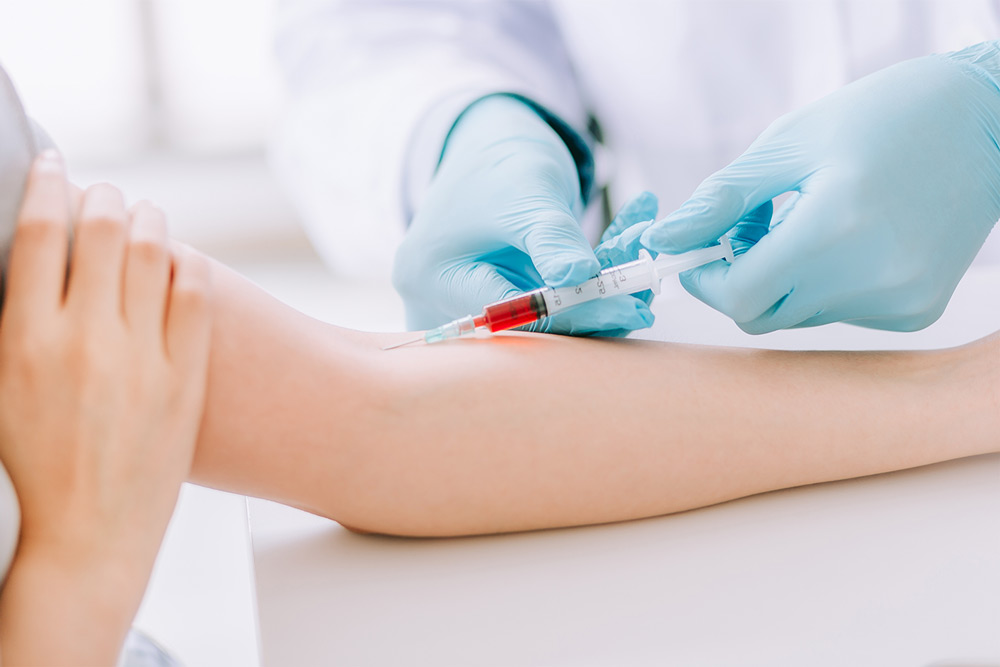 close-up of medical technician drawing blood from a patient's arm